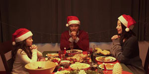 A Christmas card featuring a family praying together